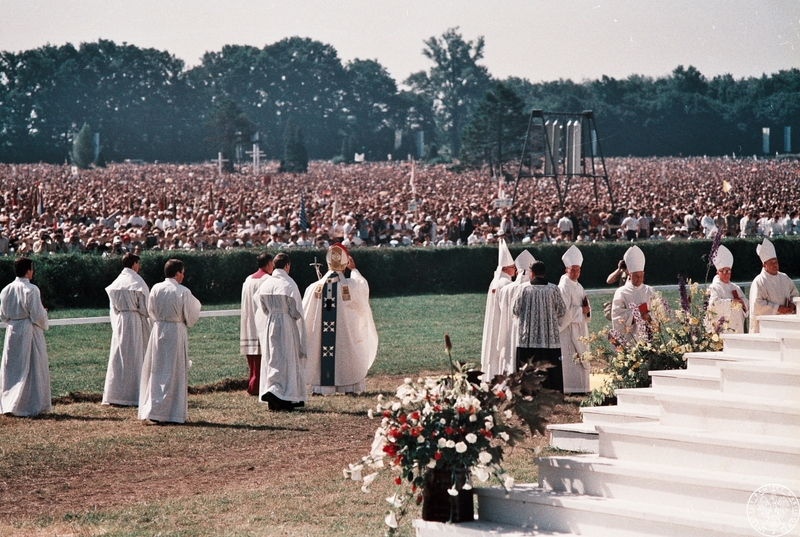Fot. nr 7. Jan Paweł II pozdrawia tłumy wiernych idąc w procesji w towarzystwie biskupów i służby liturgicznej w kierunku ołtarza na hipodromie na Partynicach. 21 VI 1983 r.  Sygnatura: IPNBU-7-14-13-431