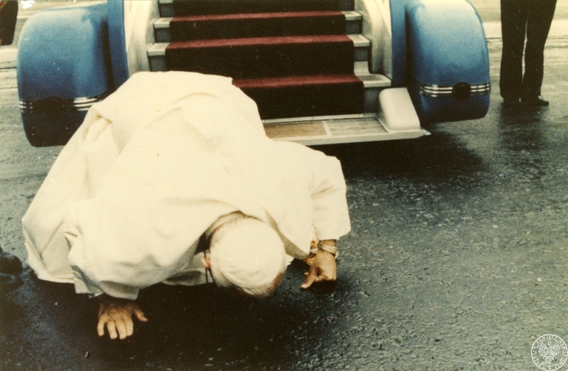 Fot. nr 1. Jan Paweł II składa pocałunek na płycie lotniska Okęcie po zejściu ze schodów samolotu. 16 VI 1983 r. Sygnatura: IPNBU-7-14-1-1