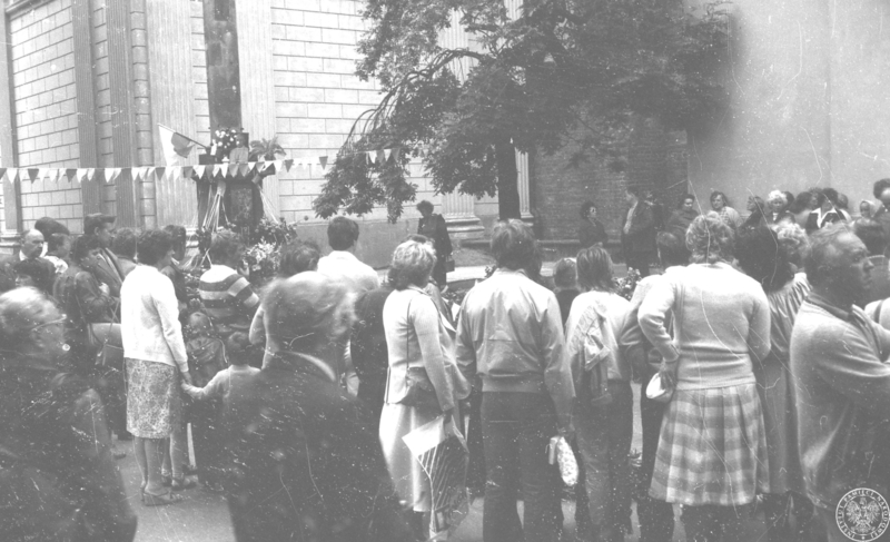 Fot. nr 1. Grupa osób zgromadzona przed kościołem Św. Anny na Krakowskim Przedmieściu wokół kwietnego krzyża ułożonego na trasie przejazdu Jana Pawła II. 17 VI 1983 r. Sygnatura: IPNBU-3-12-4-18