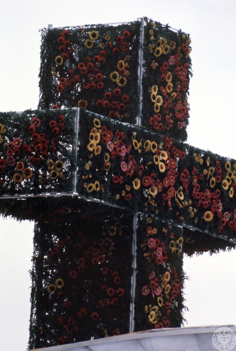 Fot. nr 3. Fragment kwietnego krzyża-elementu ołtarza papieskiego w czasie nabożeństwa na lotnisku w dzielnicy Muchowiec. 20 VI 1983 r. Sygnatura: IPNBU-7-14-13-25