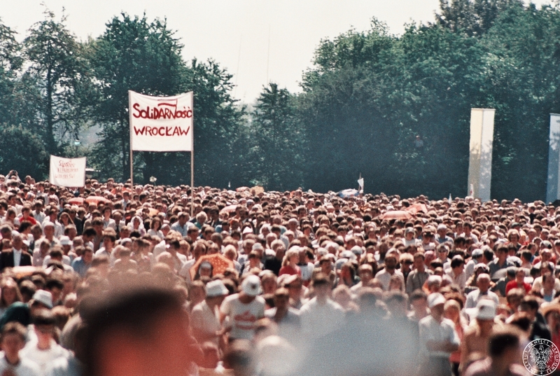 Fot. nr 2. Tłum wiernych zgromadzony na hipodromie na Partynicach. Widoczny transparent z logo „Solidarność Wrocław”. 21 VI 1983 r.  Sygnatura: IPNBU-7-14-13-340