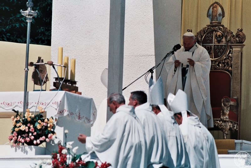 Fot. nr 4. Jan Paweł II (przemawia do mikrofonu) celebruje Mszę św. na hipodromie na Partynicach w otoczeniu duchownych. Z lewej widoczny ołtarz.  21 VI 1983 r.  Sygnatura: IPNBU-7-14-13-357