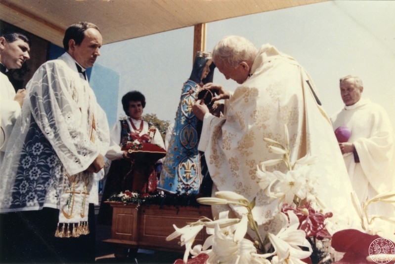 Fot. nr 3. Papież Jan Paweł II nakłada koronę na głowę Chrystusa w figurze Matki Boskiej Bolesnej z Limanowej. Obok papieża inni duchowni, w głębi kobieta w stroju ludowym. 22 VI 1983 r. Sygnatura: IPNBU-7-14-8-3