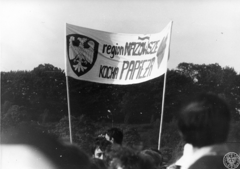 Fot. nr 2. Głowy wiernych zgromadzonych na krakowskich Błoniach. Widoczny transparent z napisem : „Region Mazowsze kocha Papieża””. 22 VI 1983 r. Sygnatura: IPNLd-16-2-4-8